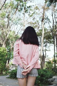 Rear view of teenage girl standing in public park