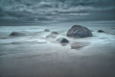 Rocks in sea against sky