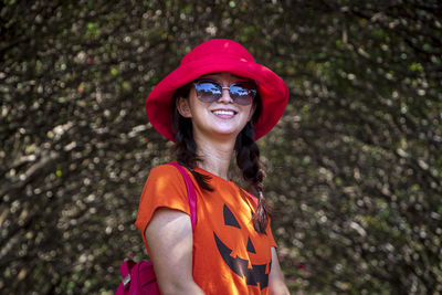 Portrait of smiling woman wearing sunglasses standing outdoors