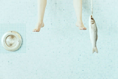 Low section of person standing by swimming pool