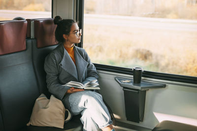 Full length of man sitting in train