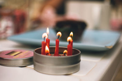 Close-up of lit candles on table