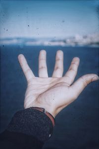 Close-up of person hand with text on water