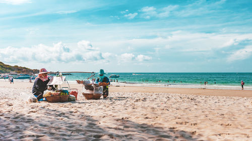 People on beach against sky