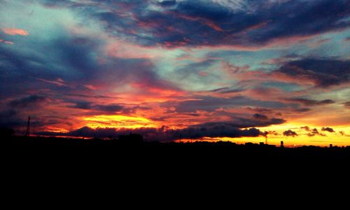 Silhouette of landscape against cloudy sky