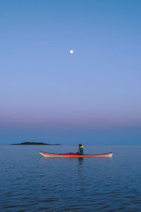 Woman on boat in sea against clear sky