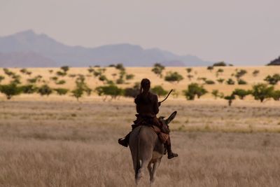 Man with horse on field against sky