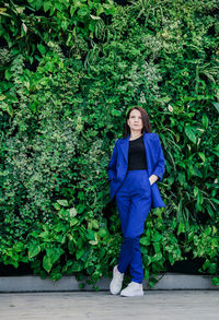 Full length of woman standing against plants