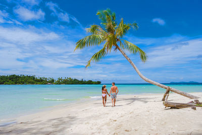 People at beach against sky