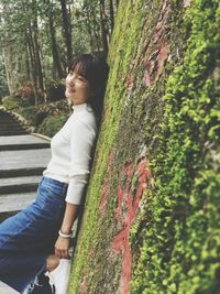 Smiling woman leaning on wall