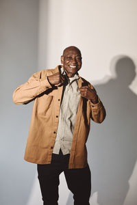 Happy senior man in casuals over white background