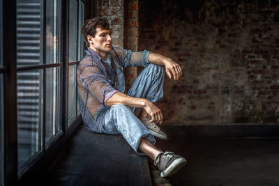 Portrait of young man sitting on staircase