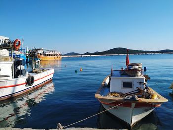 Ship moored in sea against clear blue sky