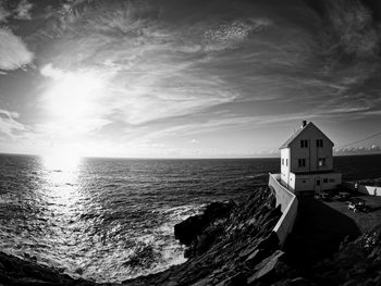 Lighthouse by sea against sky