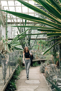 Rear view of young woman walking in greenhouse