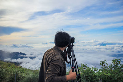 Man photographing against sky