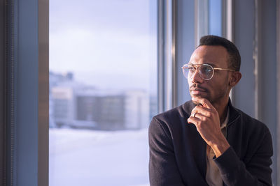 Businessman looking through office window