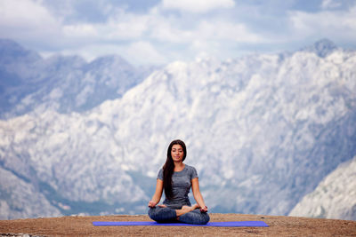 Woman practicing yoga against snowcapped mountains