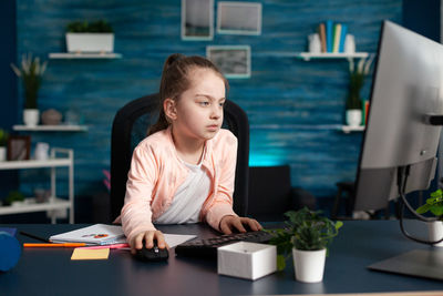 Woman looking down while sitting on table