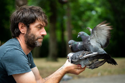 Side view of man feeding bird