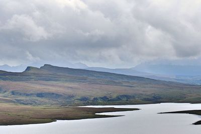 Scenic view of lake by mountains against sky