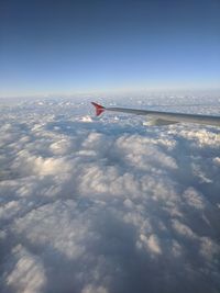 Airplane flying over cloudscape against sky