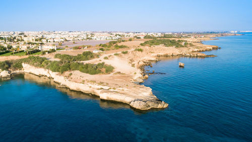 High angle view of town by sea against clear sky