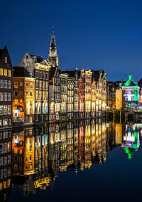 Illuminated buildings in city at night in amsterdam 