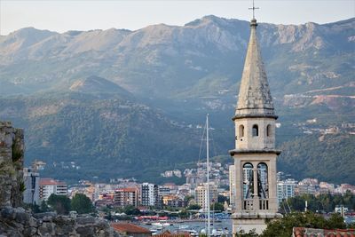 Buildings in city against mountain range