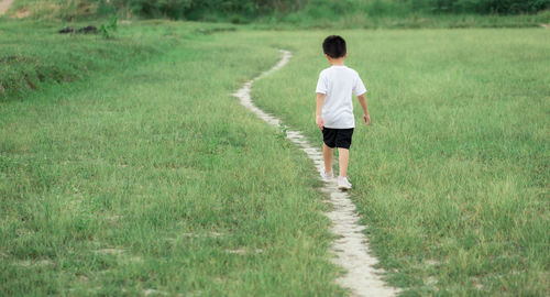 Rear view of man walking on footpath