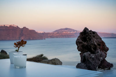 Candle and plant decoration on a white table. oia, santorini island. beautiful colors on caldera