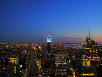 Illuminated buildings in city against sky