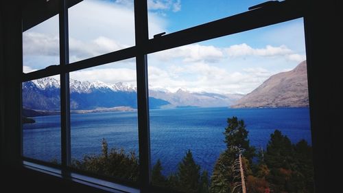 Scenic view of sea and mountains seen through window