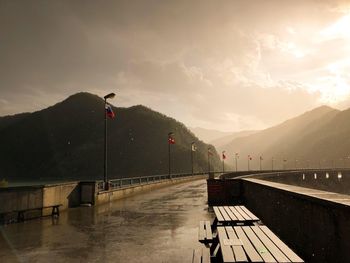 Street amidst mountains against sky during rainy season