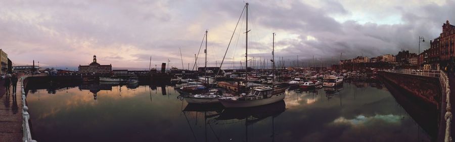 Panoramic view of harbor against cloudy sky