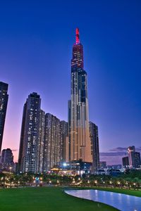 Illuminated buildings in city against clear sky