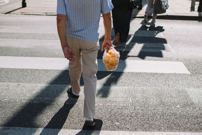 Low section of man walking on road