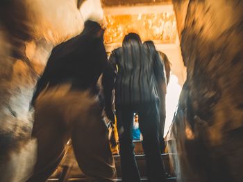 Rear view of people walking on street in city