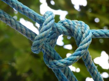 Close-up of rope tied up against blue sky