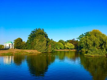 Scenic view of lake against clear blue sky