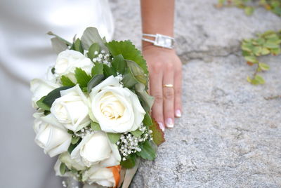 Close-up of hand holding white roses