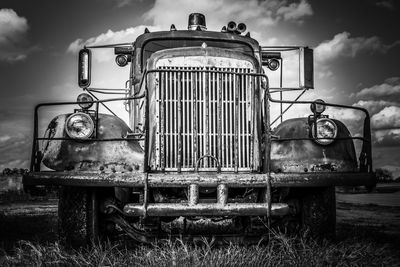 Abandoned truck on field against sky