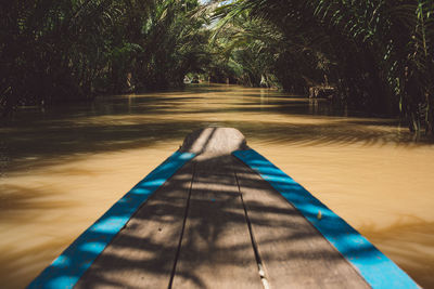 Person sitting by swimming pool in forest