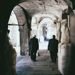 Full length rear view of woman walking on footbridge