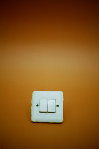 Close-up of electric lamp against wall