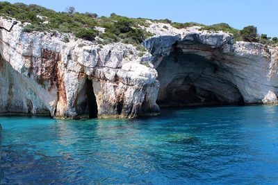 Rock formation in sea against sky