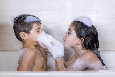 Side view of siblings in bathroom at home