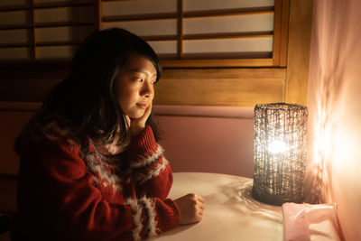 Woman looking at illuminated lighting equipment on table