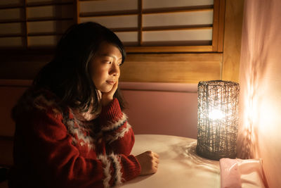 Woman looking away while sitting at home