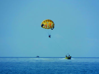 People parasailing over blue sea against sky